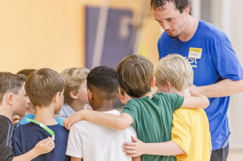 Counselor helping camper during day camp in the DMV